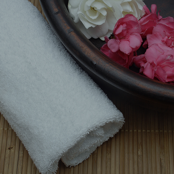 Fluffy white towel and rose petals in spa