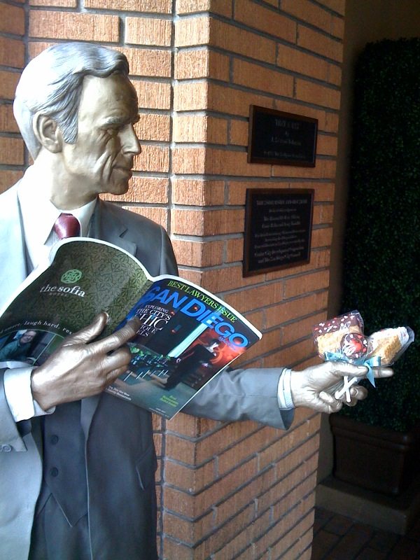 Statue of a man holding a San Diego magazine